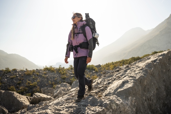 Vrouw in voorjaarsachtige trekking-kleding in de bergen