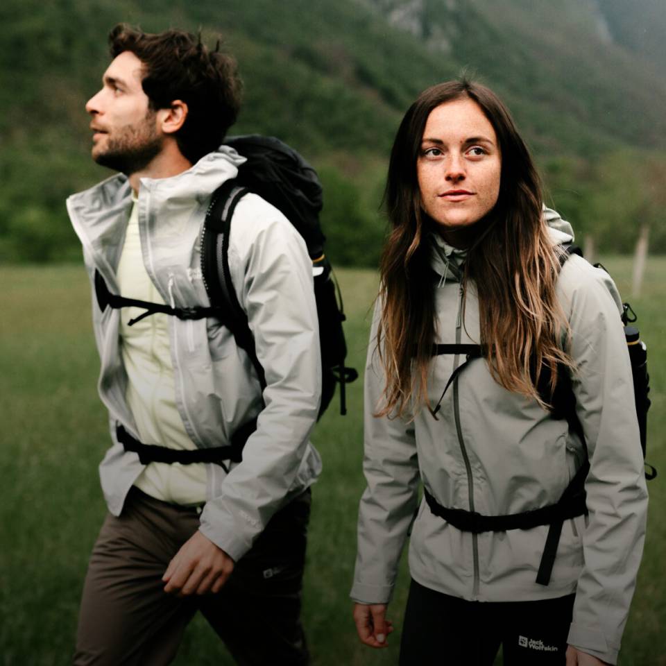  Vrouw en man in sportieve wandelkleding in een groen berglandschap