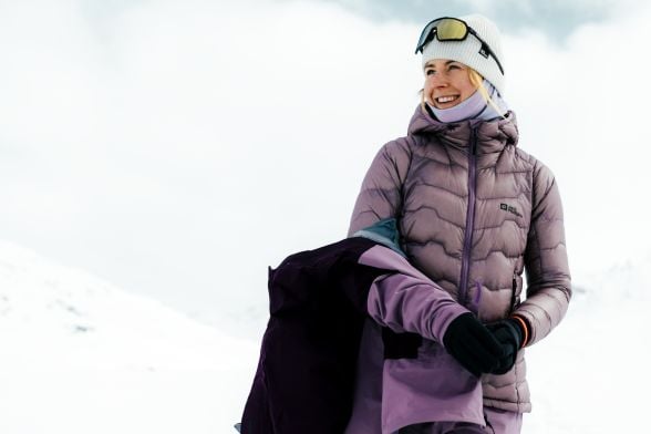 Vrouw in warme skikleding in een besneeuwd landschap